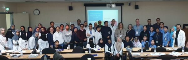 CBISTs pose with CBIS training attendees in a classroom