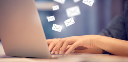 Person typing emails on laptop