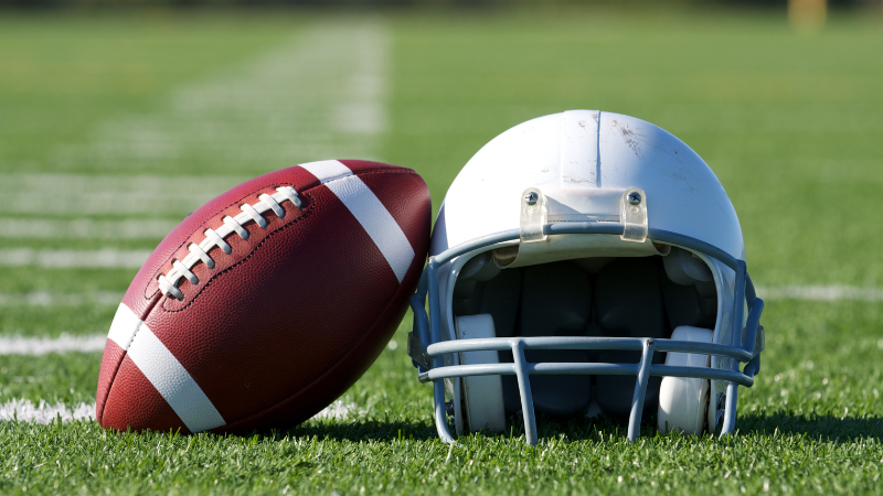 A helmet and football in a field for a story about Tua Tagovailoa's Concussion