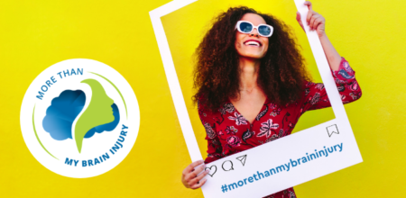 Smiling woman holding large polaroid frame with hashtag morethanmybraininjury written on it. More Than My Brain Injury Awareness logo sticker. Yellow background.