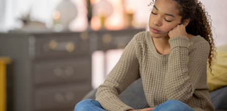 A young woman with her hair in a ponytail looks exasperated.